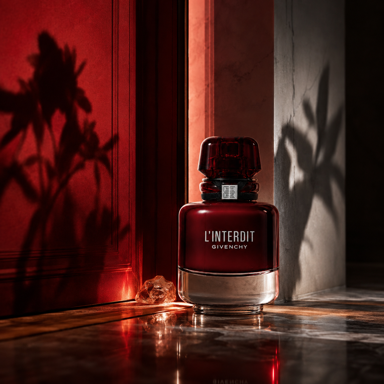 Givenchy L’Interdit Rouge EDP u červených dveří se stíny květin na stěně – MrRizz